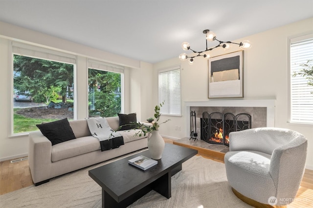 9132 NE 143rd Pl, Kirkland, WA 98034 - living room with a chandelier, a warm lit fireplace, and light wood finished floors