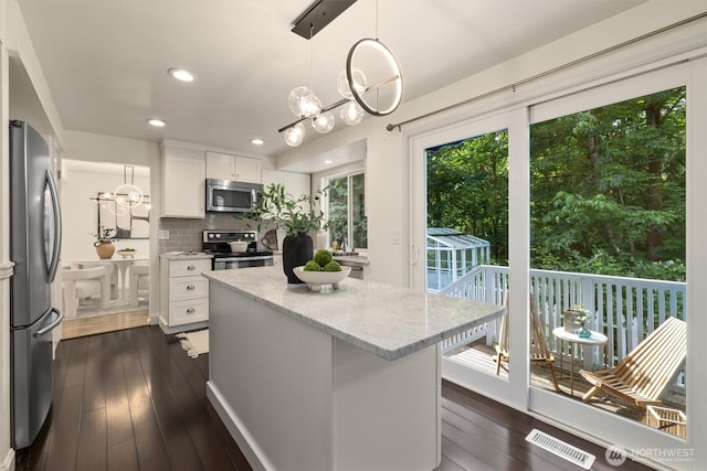 9132 NE 143rd Pl, Kirkland, WA 98034 - kitchen with appliances with stainless steel finishes, light stone counters, white cabinetry, backsplash, and a center island