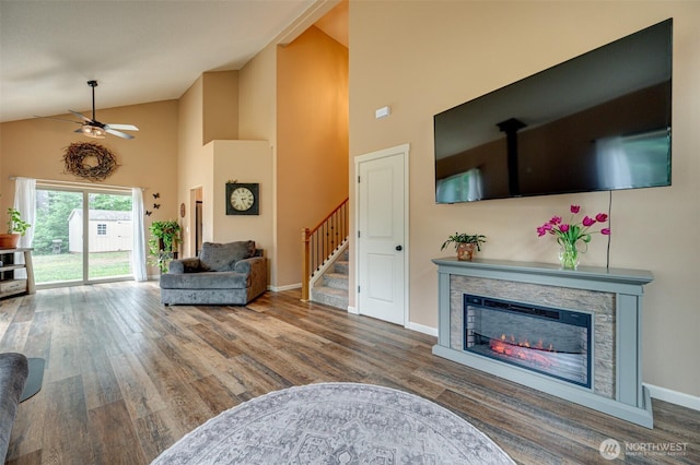 118 Bald Eagle Rd, Ariel, WA 98603 - living area featuring high vaulted ceiling, wood finished floors, ceiling fan, a stone fireplace, and stairway