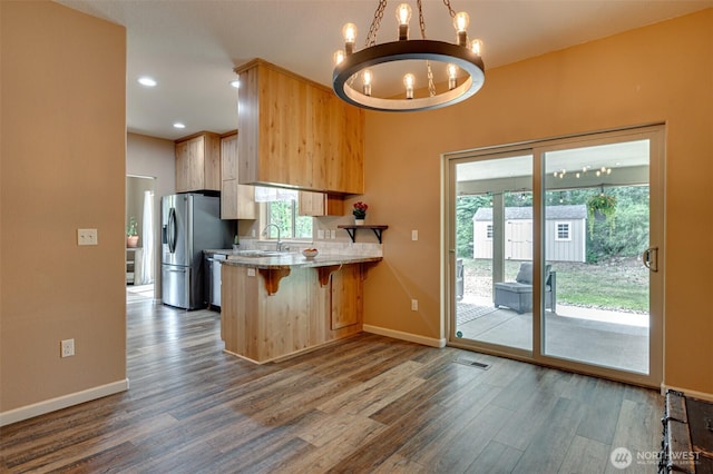 118 Bald Eagle Rd, Ariel, WA 98603 - kitchen with a chandelier, dark wood finished floors, a breakfast bar area, a peninsula, and stainless steel refrigerator with ice dispenser
