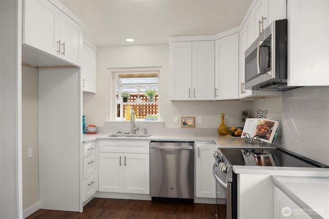 7337 19th Ave SW, Seattle, WA 98106 - kitchen with stainless steel appliances, dark wood-style flooring, white cabinetry, light countertops, and recessed lighting