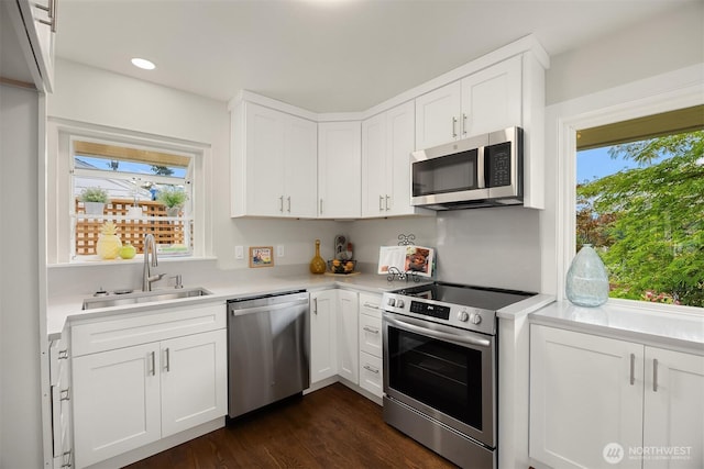 7337 19th Ave SW, Seattle, WA 98106 - kitchen featuring appliances with stainless steel finishes, light countertops, plenty of natural light, white cabinets, and recessed lighting