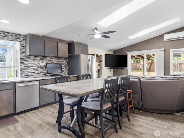 16002 5th Ave E, Tacoma, WA 98445 - dining space with a wall unit AC, a skylight, lofted ceiling, light wood-style floors, and a ceiling fan