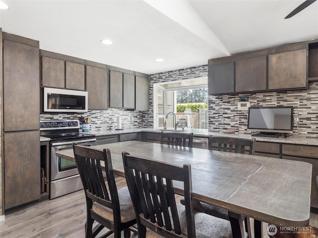 16002 5th Ave E, Tacoma, WA 98445 - kitchen featuring stainless steel range with electric stovetop, decorative backsplash, dark brown cabinetry, light wood finished floors, and recessed lighting