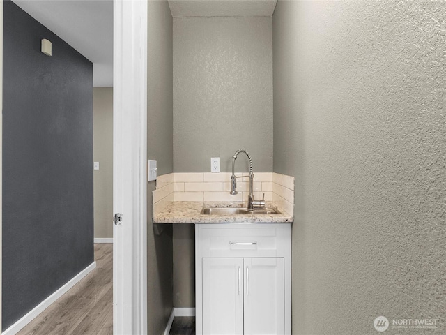 16002 5th Ave E, Tacoma, WA 98445 - bathroom featuring wood finished floors, a textured wall, vanity, and backsplash