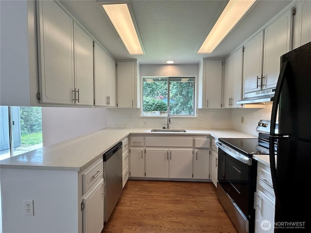 5519 65th Ave SE, Olympia, WA 98513 - kitchen with stainless steel appliances, under cabinet range hood, decorative backsplash, and light countertops