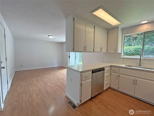 5519 65th Ave SE, Olympia, WA 98513 - kitchen featuring dishwasher, a textured ceiling, light wood-style flooring, light countertops, and decorative backsplash
