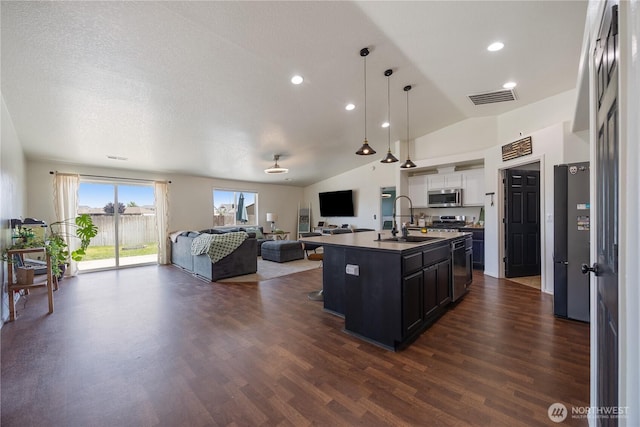 5421 Jackson Ln, Pasco, WA 99301 - kitchen with stainless steel appliances, open floor plan, white cabinetry, lofted ceiling, and dark cabinetry