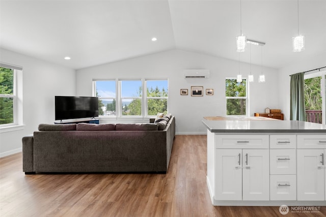 1172 Thorndyke Rd, Port Ludlow, WA 98365 - living room with vaulted ceiling, a wall unit AC, and light wood-type flooring