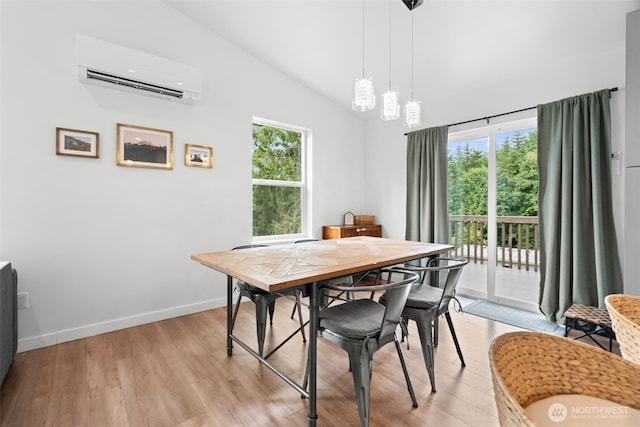 1172 Thorndyke Rd, Port Ludlow, WA 98365 - dining room featuring a wall unit AC, healthy amount of natural light, light wood-style floors, high vaulted ceiling, and a chandelier