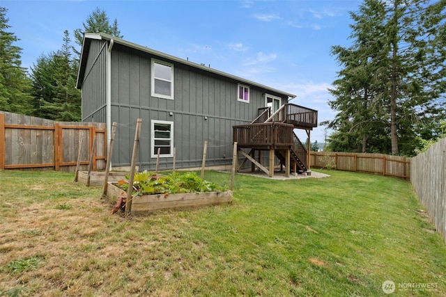 1172 Thorndyke Rd, Port Ludlow, WA 98365 - rear view of house with a fenced backyard, a garden, stairs, a wooden deck, and board and batten siding