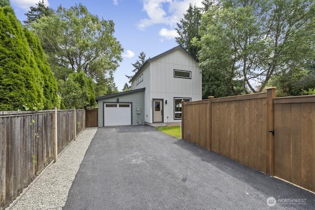 10342 39th Ave NE, Seattle, WA 98125 - view of home's exterior featuring asphalt driveway, an attached garage, and board and batten siding