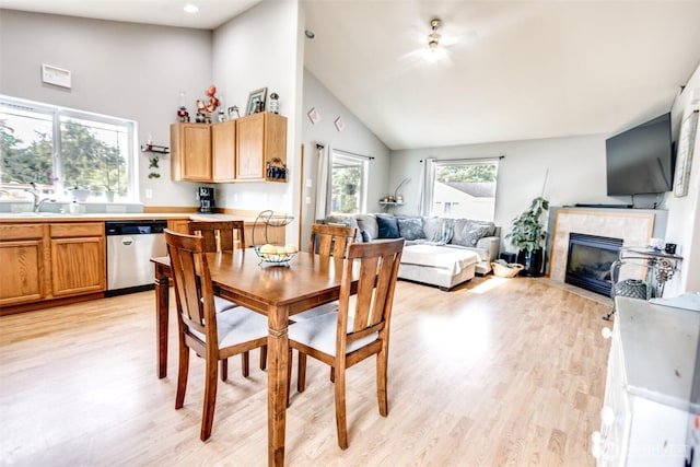 858 Willow Ct SW, Ocean Shores, WA 98569 - dining area featuring light wood finished floors, a tiled fireplace, high vaulted ceiling, and recessed lighting