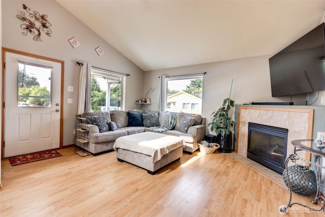 858 Willow Ct SW, Ocean Shores, WA 98569 - living room featuring light wood-type flooring, lofted ceiling, and a tiled fireplace