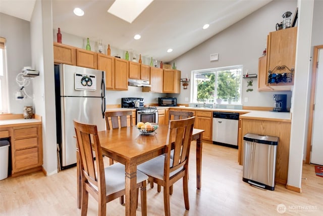 858 Willow Ct SW, Ocean Shores, WA 98569 - kitchen with stainless steel appliances, under cabinet range hood, light wood finished floors, light countertops, and a skylight