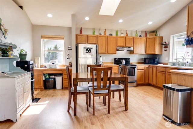858 Willow Ct SW, Ocean Shores, WA 98569 - kitchen with stainless steel electric range, under cabinet range hood, black microwave, freestanding refrigerator, and healthy amount of natural light