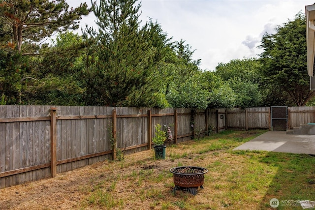 858 Willow Ct SW, Ocean Shores, WA 98569 - fenced backyard featuring a fire pit and a patio area