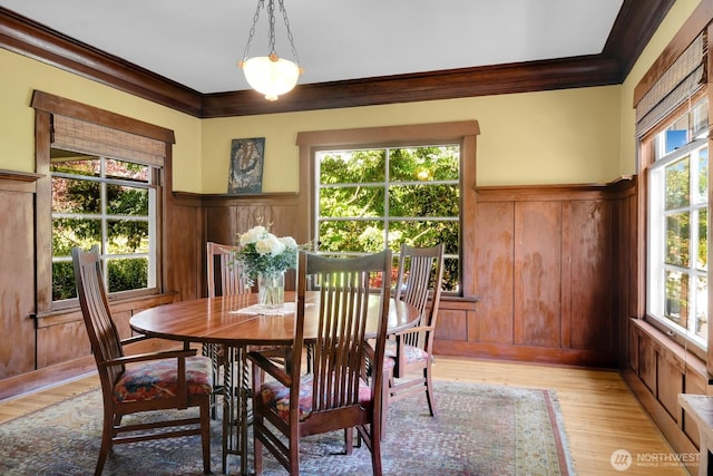 4926 42nd Ave S, Seattle, WA 98118 - dining area featuring crown molding, healthy amount of natural light, wainscoting, light wood-style floors, and a decorative wall