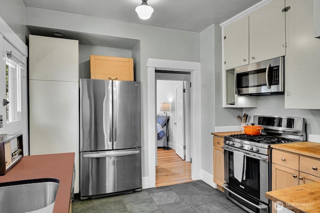 4926 42nd Ave S, Seattle, WA 98118 - kitchen with stainless steel appliances, wood counters, and light brown cabinetry
