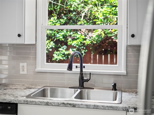 4510 N 24th St, Tacoma, WA 98406 - kitchen view of white cabinets, decorative backsplash, dishwasher, and light stone countertops