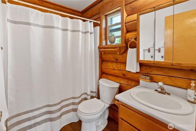 8669 Harbor Dr, Blaine, WA 98230 - full bath featuring log walls, vanity, curtained shower, and wood finished floors