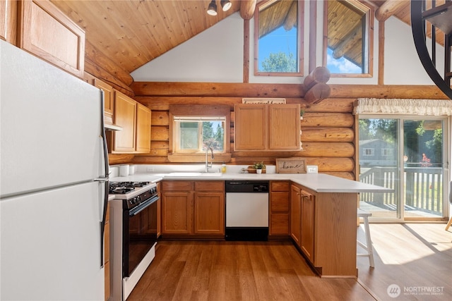 8669 Harbor Dr, Blaine, WA 98230 - kitchen featuring white appliances, log walls, a peninsula, open shelves, and light countertops
