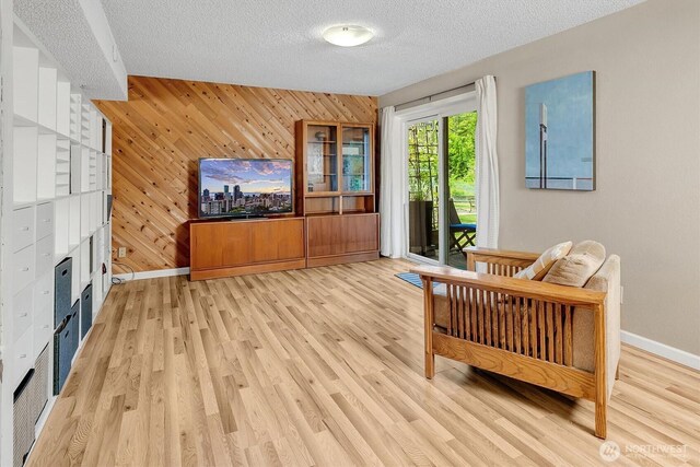 6713 128th Ave SE, Bellevue, WA 98006 - living room with light wood finished floors, wooden walls, and a textured ceiling