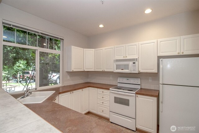 12712 Admiralty Way Unit F106, Everett, WA 98204 - kitchen with white appliances, white cabinets, light tile patterned floors, and recessed lighting