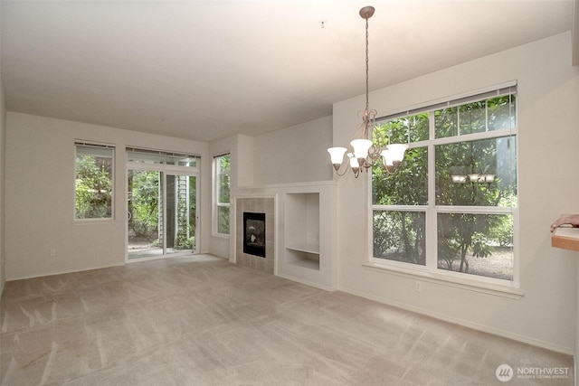 12712 Admiralty Way Unit F106, Everett, WA 98204 - unfurnished living room with a chandelier, carpet flooring, and a tiled fireplace