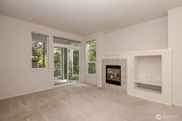12712 Admiralty Way Unit F106, Everett, WA 98204 - unfurnished living room with plenty of natural light, a tile fireplace, and carpet floors