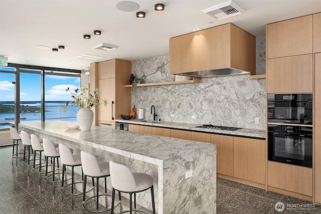 300 Virginia St Unit 1311, Seattle, WA 98101 - kitchen featuring black oven, open shelves, a kitchen breakfast bar, tasteful backsplash, and modern cabinets