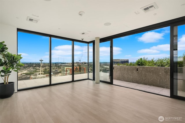 300 Virginia St Unit 1311, Seattle, WA 98101 - spare room featuring expansive windows, wood finished floors, and a smoke detector