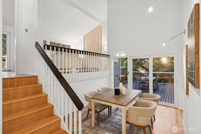 1564 Hillside Dr SE, Issaquah, WA 98027 - dining area featuring a towering ceiling, wood finished floors, stairs, and a chandelier