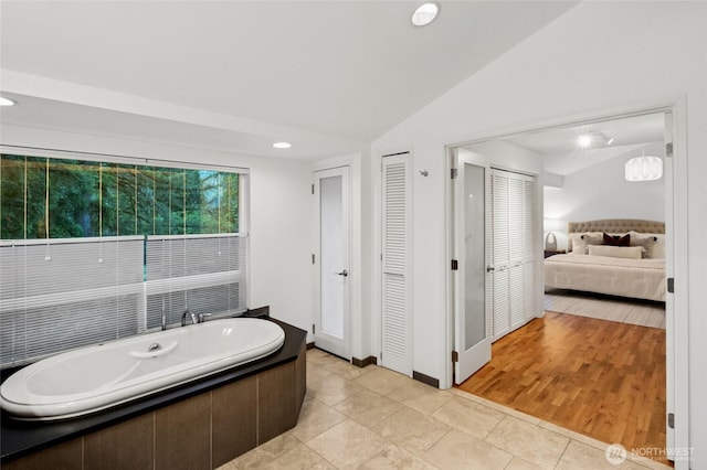 1564 Hillside Dr SE, Issaquah, WA 98027 - ensuite bathroom featuring a bath, a closet, lofted ceiling, and recessed lighting
