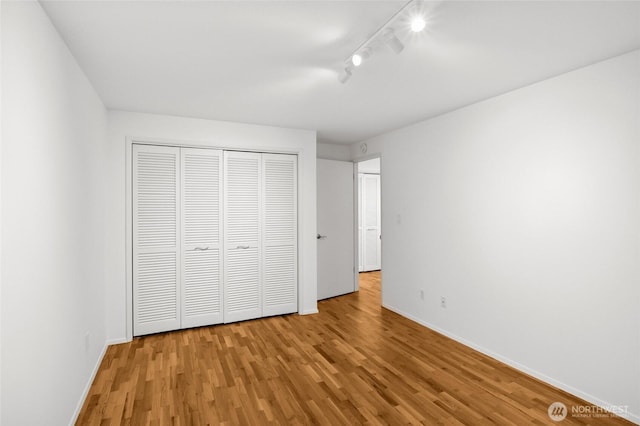 1564 Hillside Dr SE, Issaquah, WA 98027 - unfurnished bedroom with wood finished floors, track lighting, and a closet