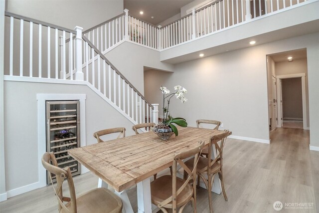 16321 SE 133rd Pl, Renton, WA 98059 - dining room with beverage cooler, a high ceiling, light wood-type flooring, recessed lighting, and stairs