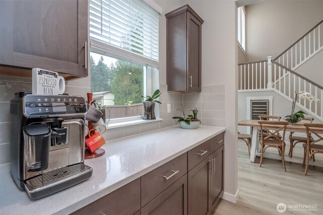 16321 SE 133rd Pl, Renton, WA 98059 - kitchen with decorative backsplash, light wood-type flooring, light stone countertops, and dark brown cabinetry