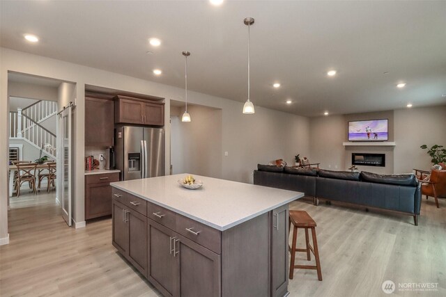 16321 SE 133rd Pl, Renton, WA 98059 - kitchen featuring stainless steel refrigerator with ice dispenser, light wood-style floors, a kitchen island, light countertops, and pendant lighting