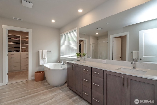 16321 SE 133rd Pl, Renton, WA 98059 - full bathroom with double vanity, a stall shower, wood finished floors, a freestanding bath, and a spacious closet