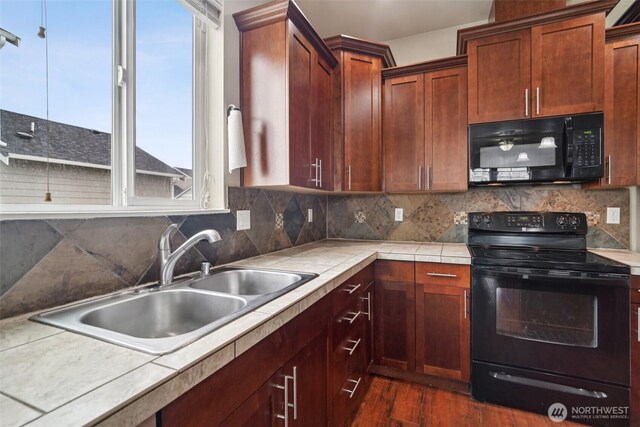 14403 Lockwood Ln SE, Yelm, WA 98597 - kitchen with black appliances, dark wood-style flooring, backsplash, and light countertops
