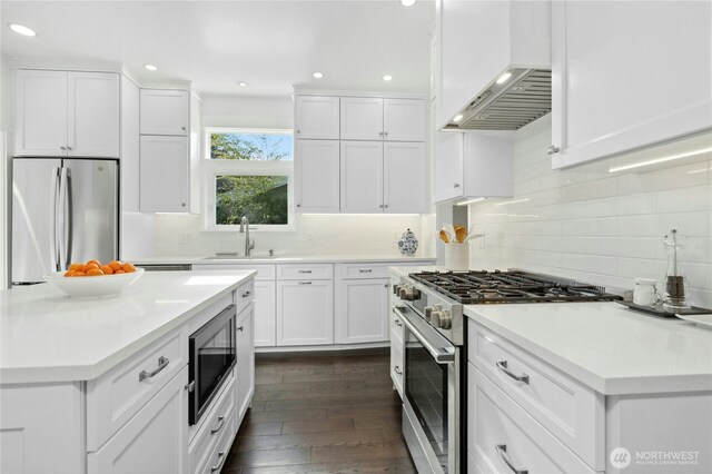 3232 37th Ave S, Seattle, WA 98144 - kitchen with appliances with stainless steel finishes, custom exhaust hood, white cabinetry, dark wood-style flooring, and light countertops