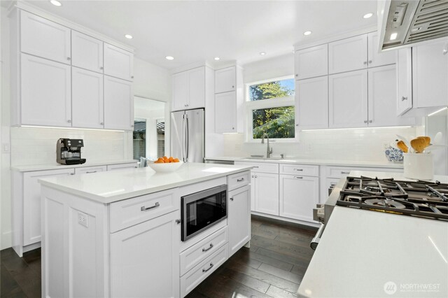 3232 37th Ave S, Seattle, WA 98144 - kitchen with stainless steel appliances, premium range hood, white cabinets, dark wood-style floors, and tasteful backsplash