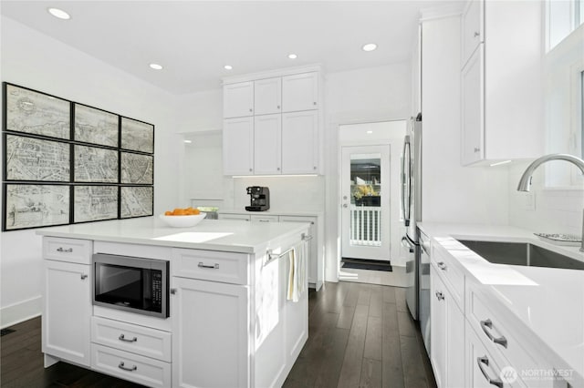 3232 37th Ave S, Seattle, WA 98144 - kitchen with appliances with stainless steel finishes, dark wood finished floors, white cabinets, light countertops, and recessed lighting