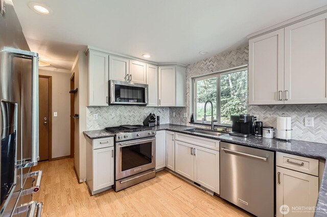 9806 6th Pl SE, Lake Stevens, WA 98258 - kitchen with stainless steel appliances, backsplash, light wood finished floors, dark stone countertops, and recessed lighting