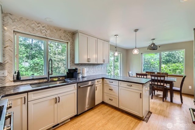 9806 6th Pl SE, Lake Stevens, WA 98258 - kitchen featuring stainless steel dishwasher, a peninsula, tasteful backsplash, decorative light fixtures, and light wood-type flooring