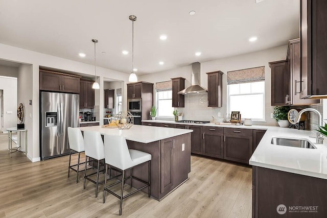 16204 SE 133rd Pl Unit 101, Renton, WA 98059 - kitchen featuring stainless steel appliances, wall chimney exhaust hood, a kitchen island, dark brown cabinetry, and recessed lighting