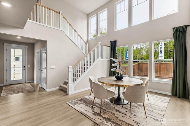16204 SE 133rd Pl Unit 101, Renton, WA 98059 - dining room featuring a towering ceiling, stairs, light wood-style flooring, and recessed lighting
