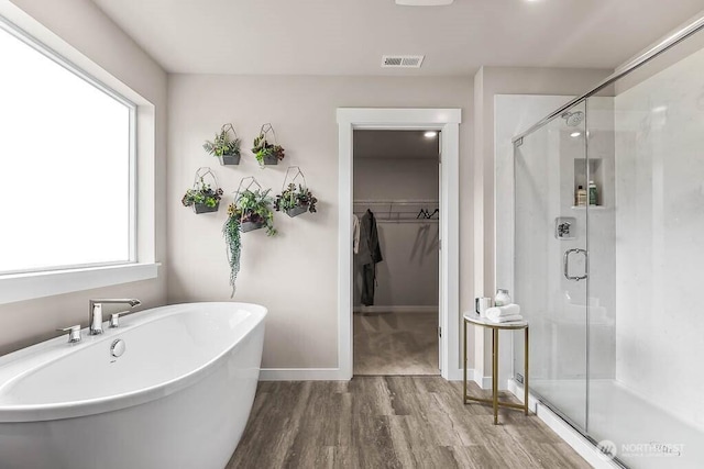 16204 SE 133rd Pl Unit 101, Renton, WA 98059 - bathroom with wood finished floors, a shower stall, a soaking tub, and a walk in closet