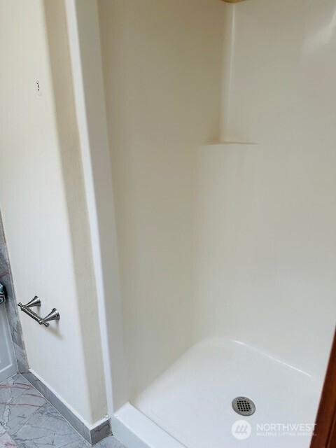 6829 Weedin Pl NE, Seattle, WA 98115 - bathroom featuring a shower stall and marble look tile flooring