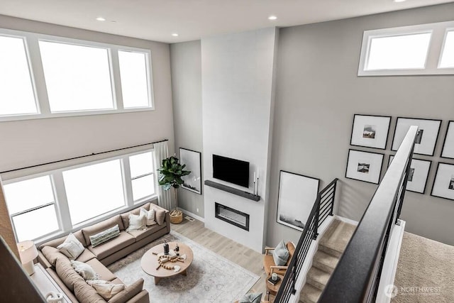 13212 164th Ave SE Unit 207, Renton, WA 98059 - living area with a glass covered fireplace, wood finished floors, recessed lighting, and a high ceiling